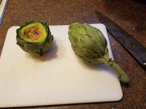 one cleaned and one uncleaned artichoke